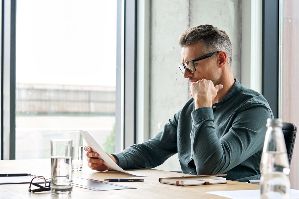 Professional man at a desk reading documents in the office