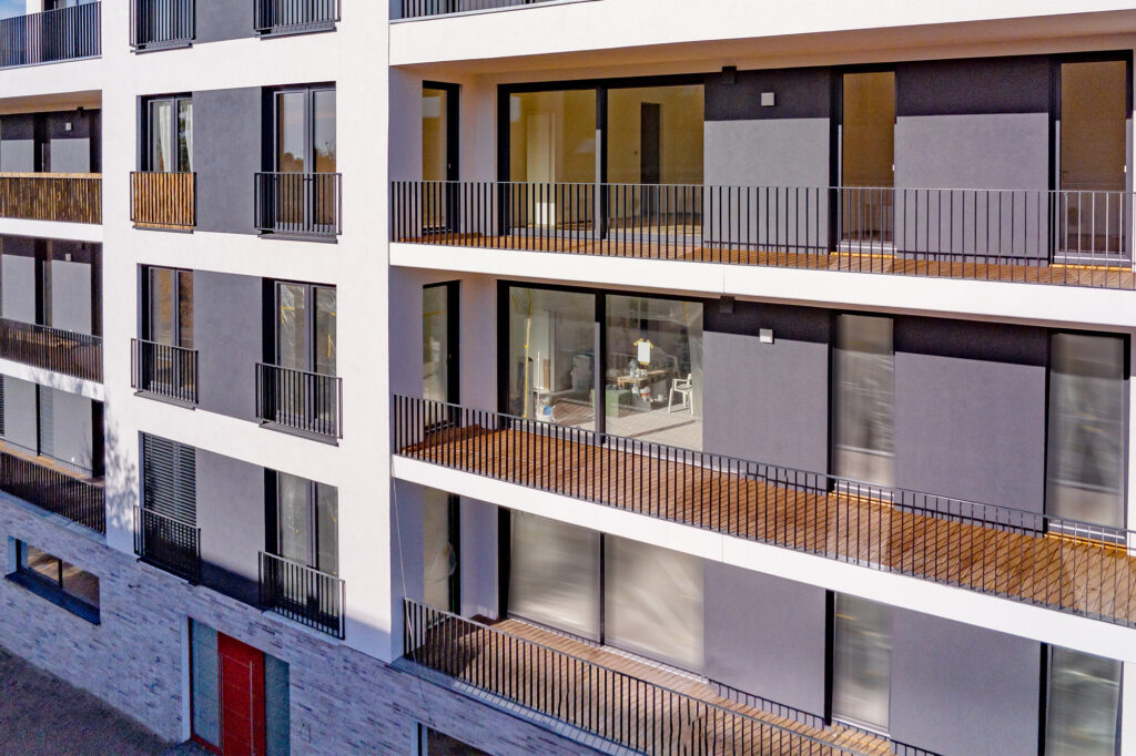 White brick and glass apartment building with red door