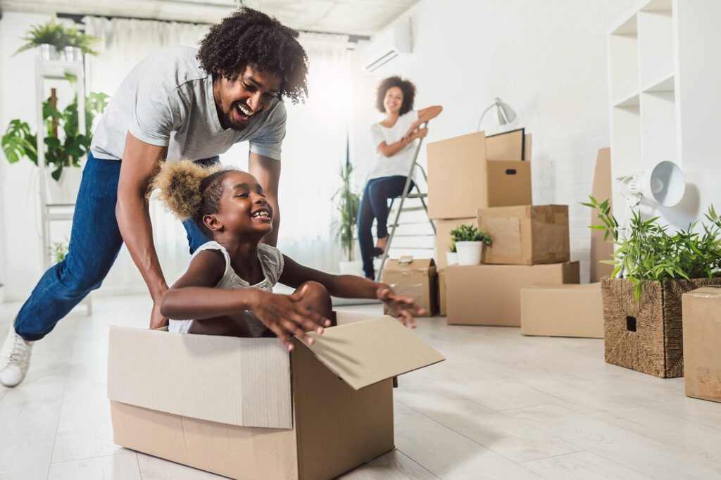 A young family moving into a new home with cardboard boxes